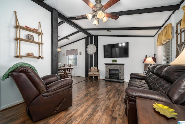 living room with vaulted ceiling with beams, dark hardwood / wood-style floors, ceiling fan, and a stone fireplace