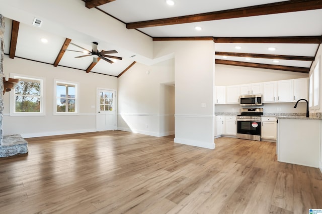 unfurnished living room with high vaulted ceiling, sink, ceiling fan, beam ceiling, and light hardwood / wood-style floors