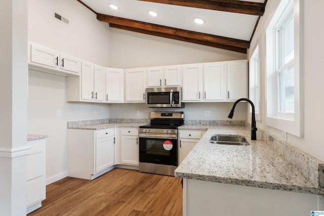 kitchen with white cabinets, sink, light hardwood / wood-style flooring, appliances with stainless steel finishes, and light stone counters