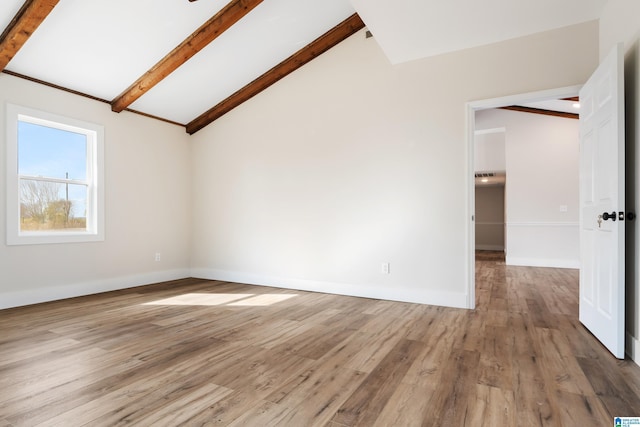 unfurnished room featuring hardwood / wood-style floors and lofted ceiling with beams