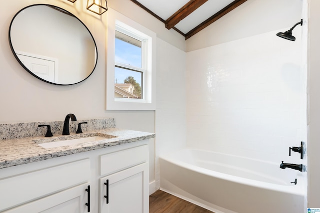 bathroom featuring bathtub / shower combination, wood-type flooring, vaulted ceiling with beams, and vanity