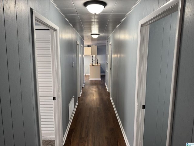 hall with dark hardwood / wood-style flooring and ornamental molding