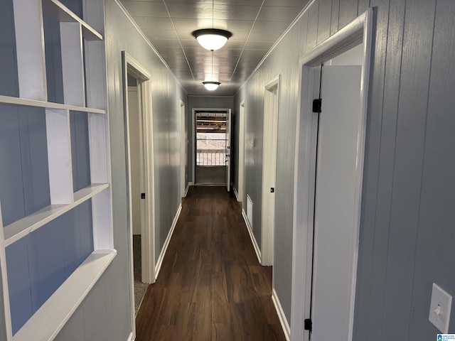 corridor with dark hardwood / wood-style flooring and crown molding