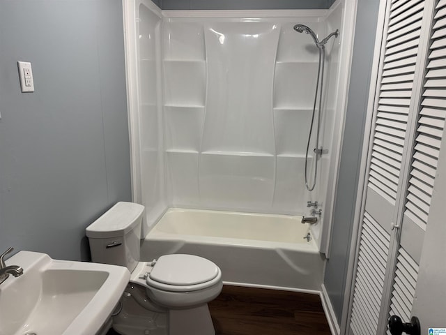 full bathroom with hardwood / wood-style floors, toilet, sink, and shower / washtub combination