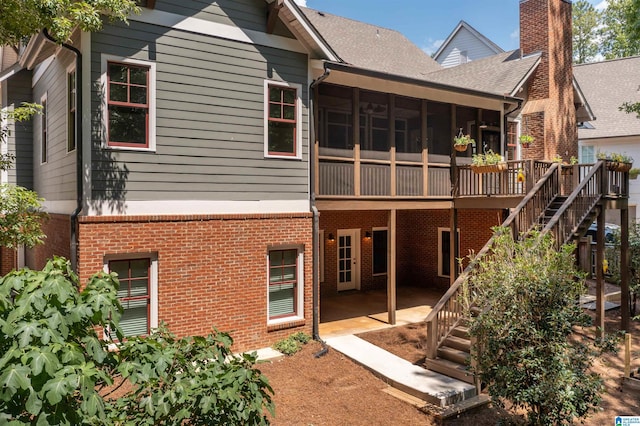 back of house with a sunroom and a patio