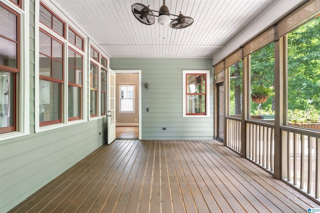 unfurnished sunroom with ceiling fan