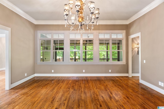 unfurnished room with hardwood / wood-style flooring, a chandelier, and ornamental molding