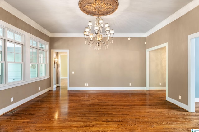 unfurnished dining area featuring crown molding, dark hardwood / wood-style floors, and a notable chandelier