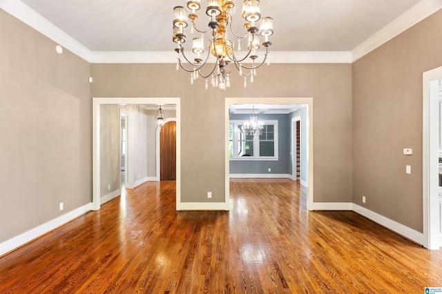 unfurnished dining area with crown molding, wood-type flooring, and an inviting chandelier