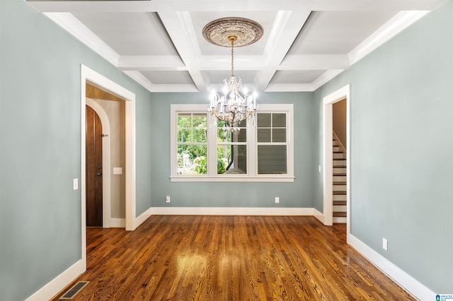 unfurnished dining area with beamed ceiling, dark hardwood / wood-style floors, a chandelier, and coffered ceiling