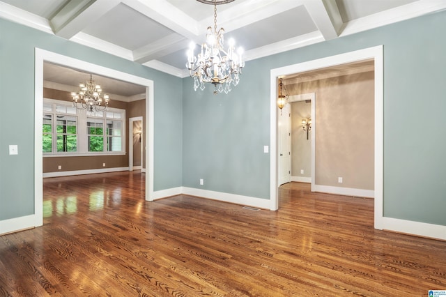 spare room with coffered ceiling, beamed ceiling, dark hardwood / wood-style floors, a notable chandelier, and ornamental molding