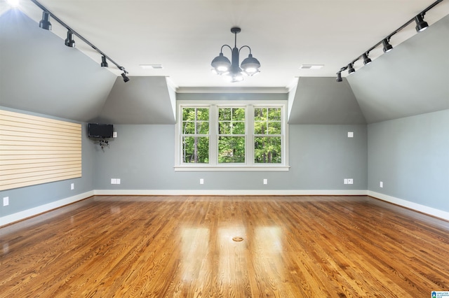 bonus room featuring hardwood / wood-style flooring, lofted ceiling, and a notable chandelier