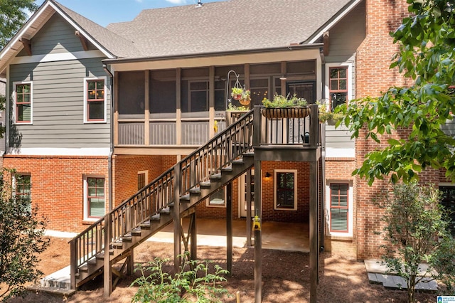 rear view of property featuring a patio and a sunroom