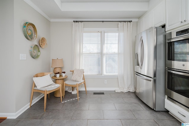 kitchen featuring crown molding, plenty of natural light, white cabinets, and appliances with stainless steel finishes