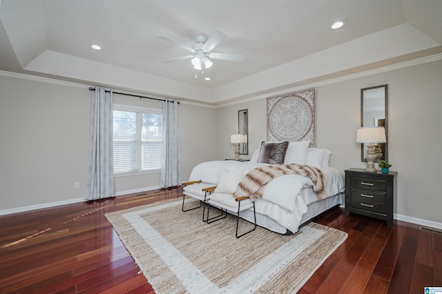 bedroom featuring a tray ceiling, ceiling fan, crown molding, and dark hardwood / wood-style floors