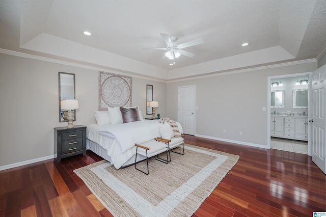 bedroom featuring ensuite bath, a tray ceiling, ceiling fan, crown molding, and dark hardwood / wood-style floors