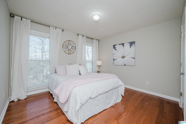 bedroom with hardwood / wood-style flooring and a textured ceiling