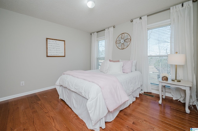 bedroom featuring wood-type flooring and a textured ceiling