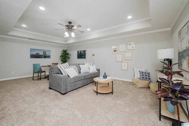 living room featuring light colored carpet, a raised ceiling, ceiling fan, and ornamental molding