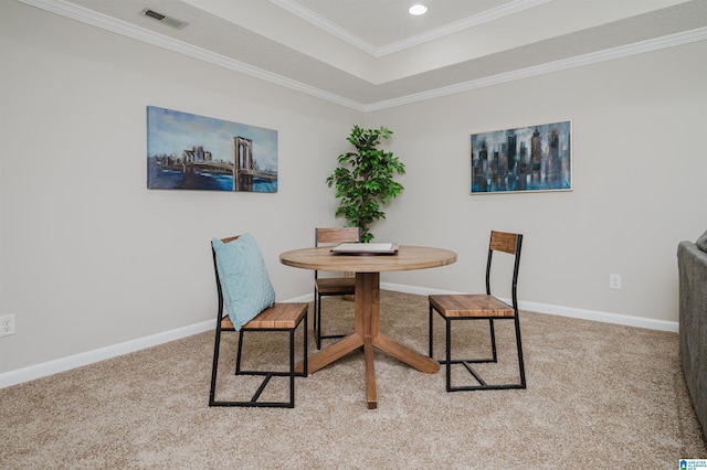 carpeted dining room featuring a tray ceiling and crown molding