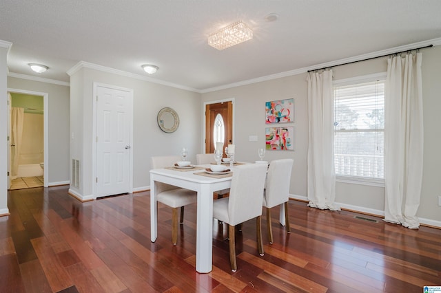 dining space featuring a chandelier, dark wood-type flooring, and ornamental molding