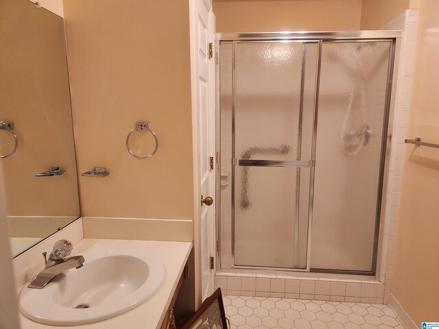 bathroom featuring vanity and a shower with door