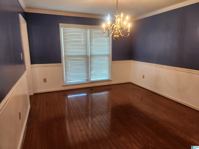 empty room with dark hardwood / wood-style floors, crown molding, and an inviting chandelier