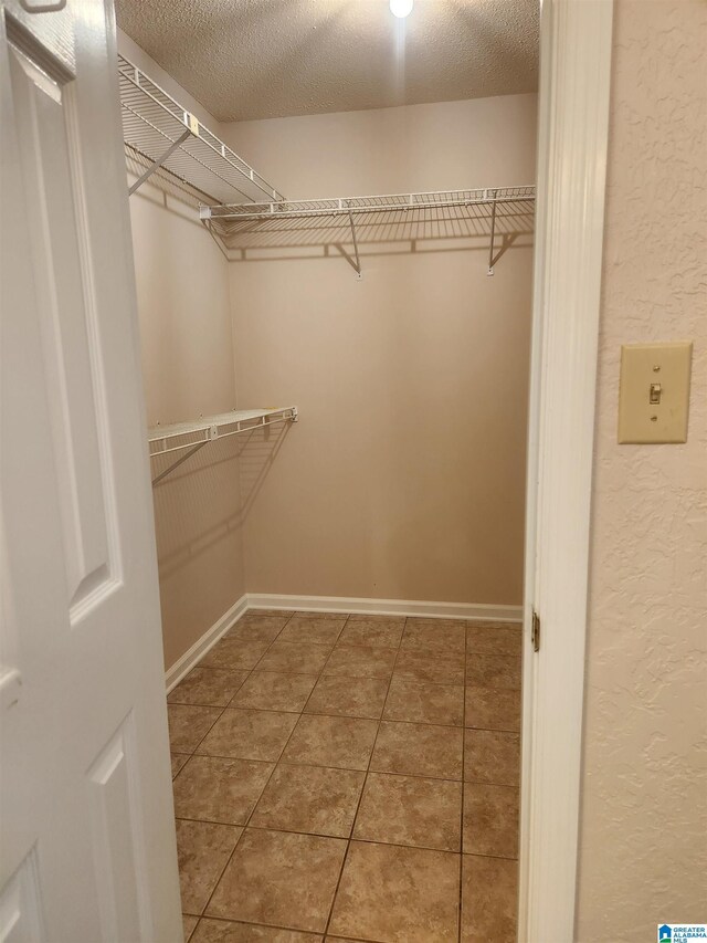 walk in closet with tile patterned floors