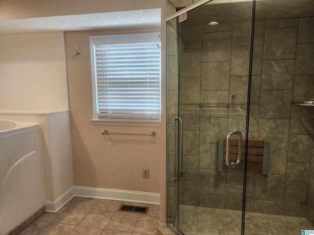 bathroom with tile patterned floors and a shower with door