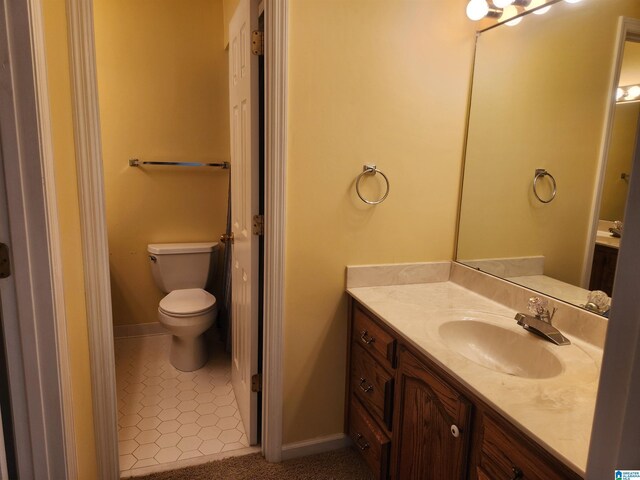 bathroom featuring tile patterned floors, vanity, and toilet