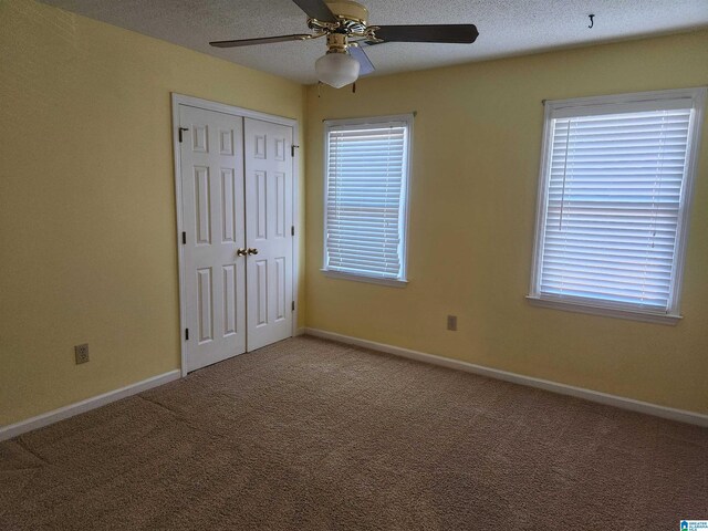 unfurnished bedroom with ceiling fan, a closet, and carpet