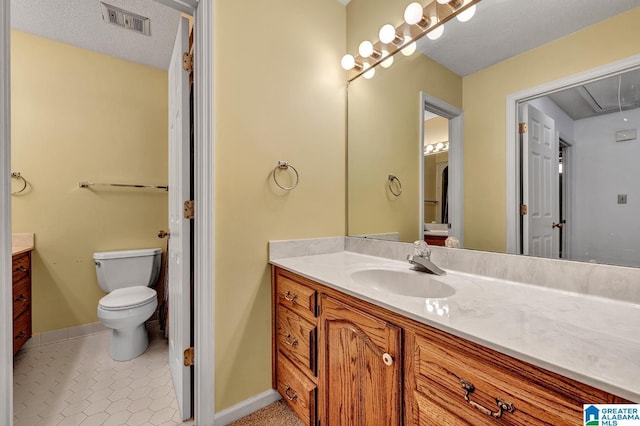 bathroom featuring tile patterned flooring, vanity, a textured ceiling, and toilet