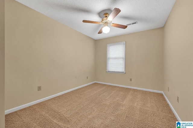 empty room featuring ceiling fan, carpet floors, and a textured ceiling