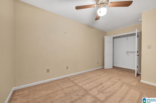 unfurnished bedroom featuring light carpet, a closet, and ceiling fan