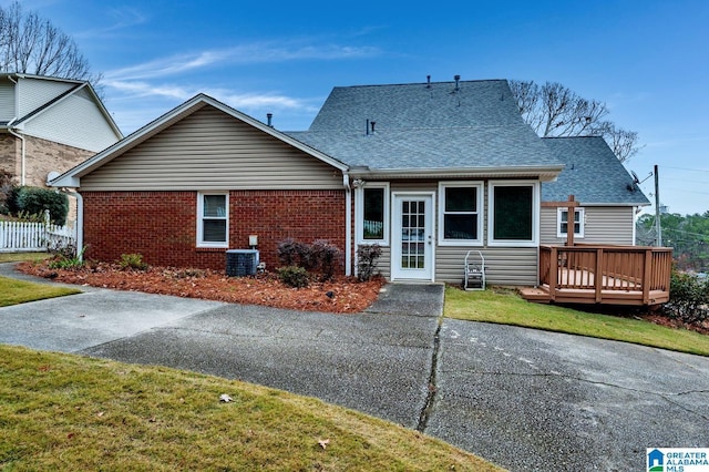 back of property featuring a yard, central AC unit, and a deck