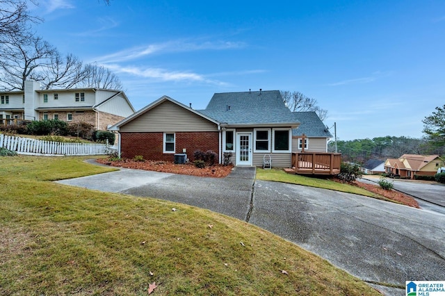 back of property featuring a yard and a wooden deck