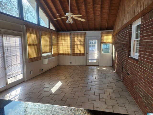 unfurnished sunroom featuring vaulted ceiling with beams, a healthy amount of sunlight, and wood ceiling