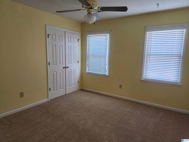 unfurnished bedroom with carpet, ceiling fan, and a closet