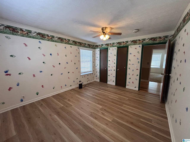 unfurnished bedroom with ceiling fan, hardwood / wood-style floors, and a textured ceiling