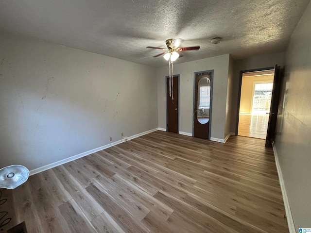 unfurnished bedroom with ceiling fan, light hardwood / wood-style floors, and a textured ceiling