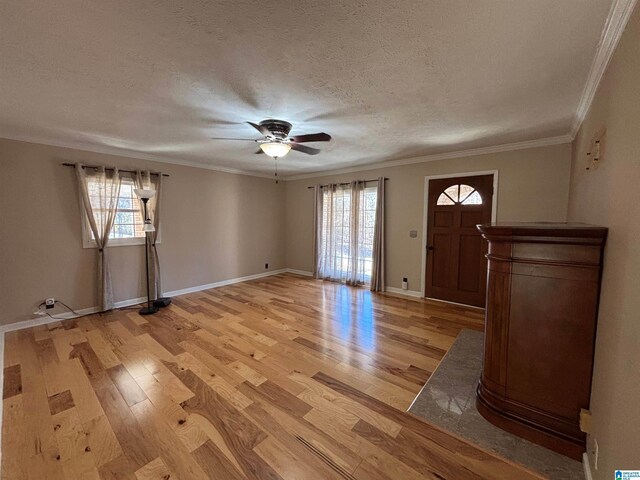 foyer entrance featuring a textured ceiling, light hardwood / wood-style flooring, and crown molding