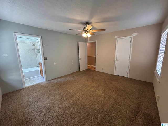 unfurnished bedroom with ceiling fan, carpet floors, a textured ceiling, and connected bathroom