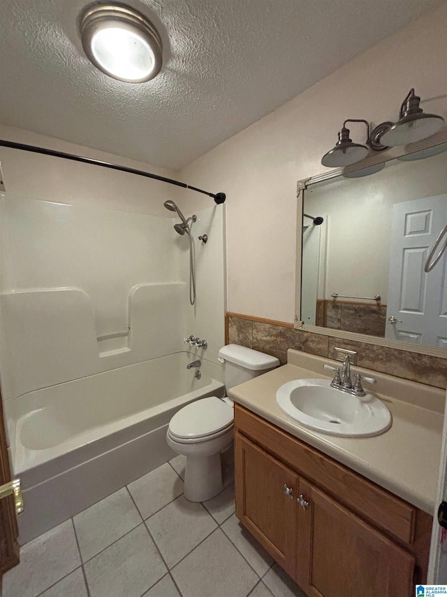 full bathroom featuring tile patterned flooring, bathing tub / shower combination, a textured ceiling, toilet, and vanity