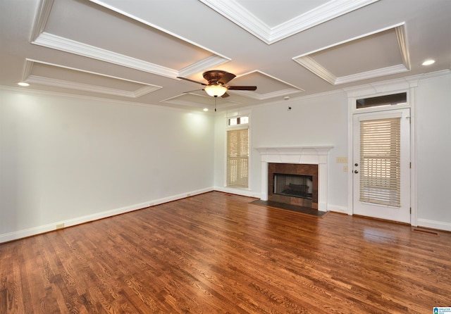 unfurnished living room featuring ceiling fan, coffered ceiling, dark hardwood / wood-style floors, a fireplace, and ornamental molding