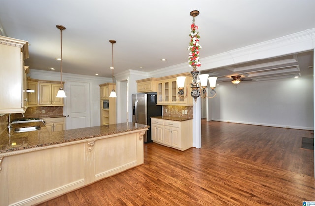 kitchen with kitchen peninsula, decorative backsplash, hanging light fixtures, and appliances with stainless steel finishes