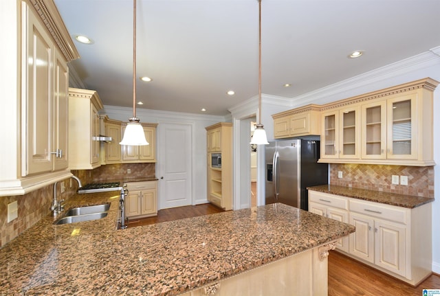 kitchen with decorative backsplash, appliances with stainless steel finishes, ornamental molding, sink, and hanging light fixtures