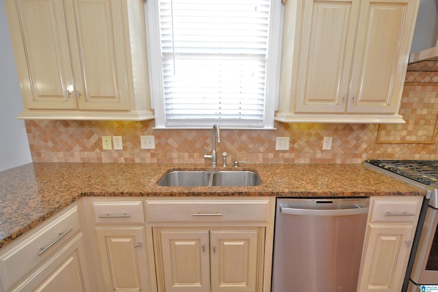 kitchen featuring backsplash, light stone counters, sink, and appliances with stainless steel finishes