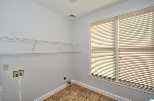 laundry area featuring hookup for an electric dryer, hookup for a washing machine, a healthy amount of sunlight, and light tile patterned flooring