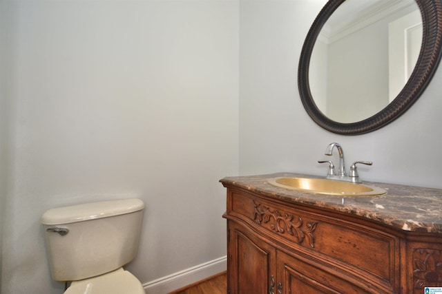 bathroom featuring crown molding, vanity, hardwood / wood-style flooring, and toilet