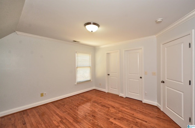 unfurnished bedroom featuring hardwood / wood-style floors, ornamental molding, and a closet